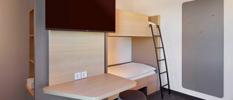 Een kleine kamer met een stapelbed, een bureau en een ladder.