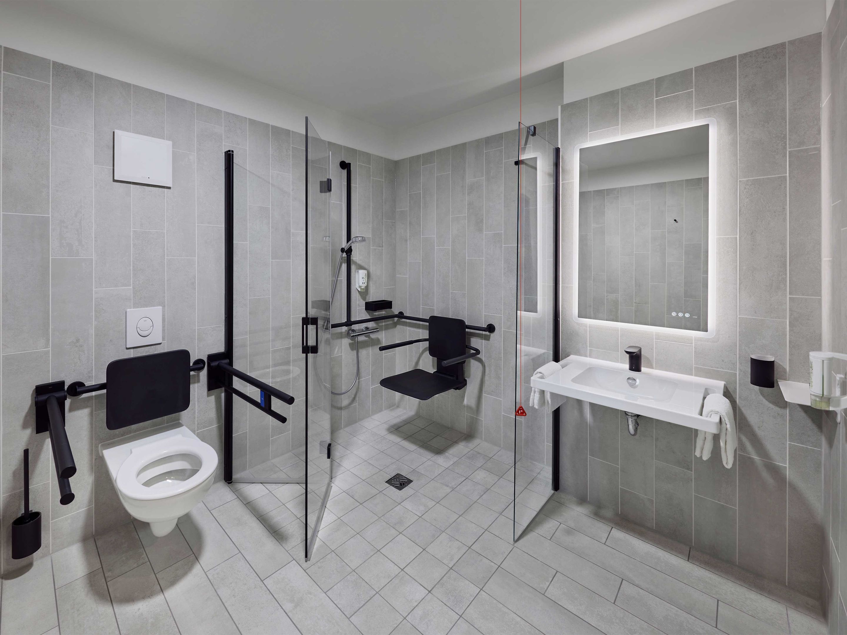 Un baño moderno con inodoro, lavabo y zona de ducha.