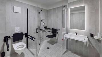 Un baño moderno con inodoro, lavabo y zona de ducha.