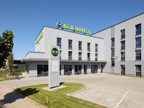 A B&B hotel with a modern design, featuring a large entrance and a parking area. - B&B HOTEL Emmerich (Emmerich)