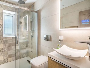 Chuveiro, toalhas de banho, papel higiênico