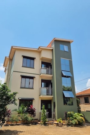 A multi-story residential building with balconies and solar panels. - BLT Apartments - peaches (Kira Town)