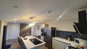 A modern kitchen with a central island, stainless steel appliances, and a microwave on the countertop. - 5 Bed Sleeps 10 Full Kitchen Parking (South Ayrshire Council)