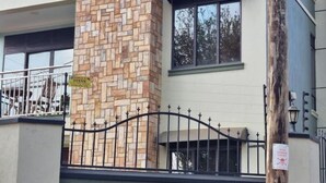 A building with a stone facade and a metal gate. - BLT Apartments - classy (Kira Town)