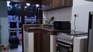 A kitchen with a stove, oven, microwave, and cabinets. - BLT Apartments - classy (Kira Town)