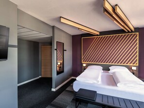 A modern hotel room with a bed, bedside tables, a large mirror, and a unique geometric wall design. - B&B HOTEL Wien-Heilligenstadt (Vienna)