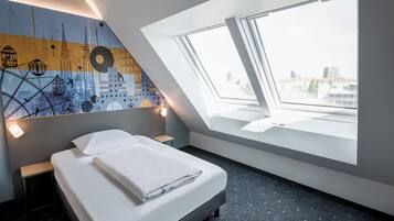 A modern bedroom with a skylight, a bed, a nightstand, and a wall mural.
