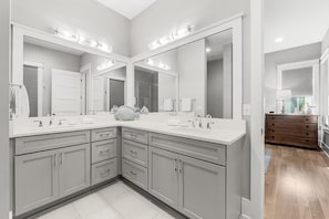 A modern bathroom with a large vanity, double sinks, and a large mirror. - Pineapple & Palms (Santa Rosa Beach)