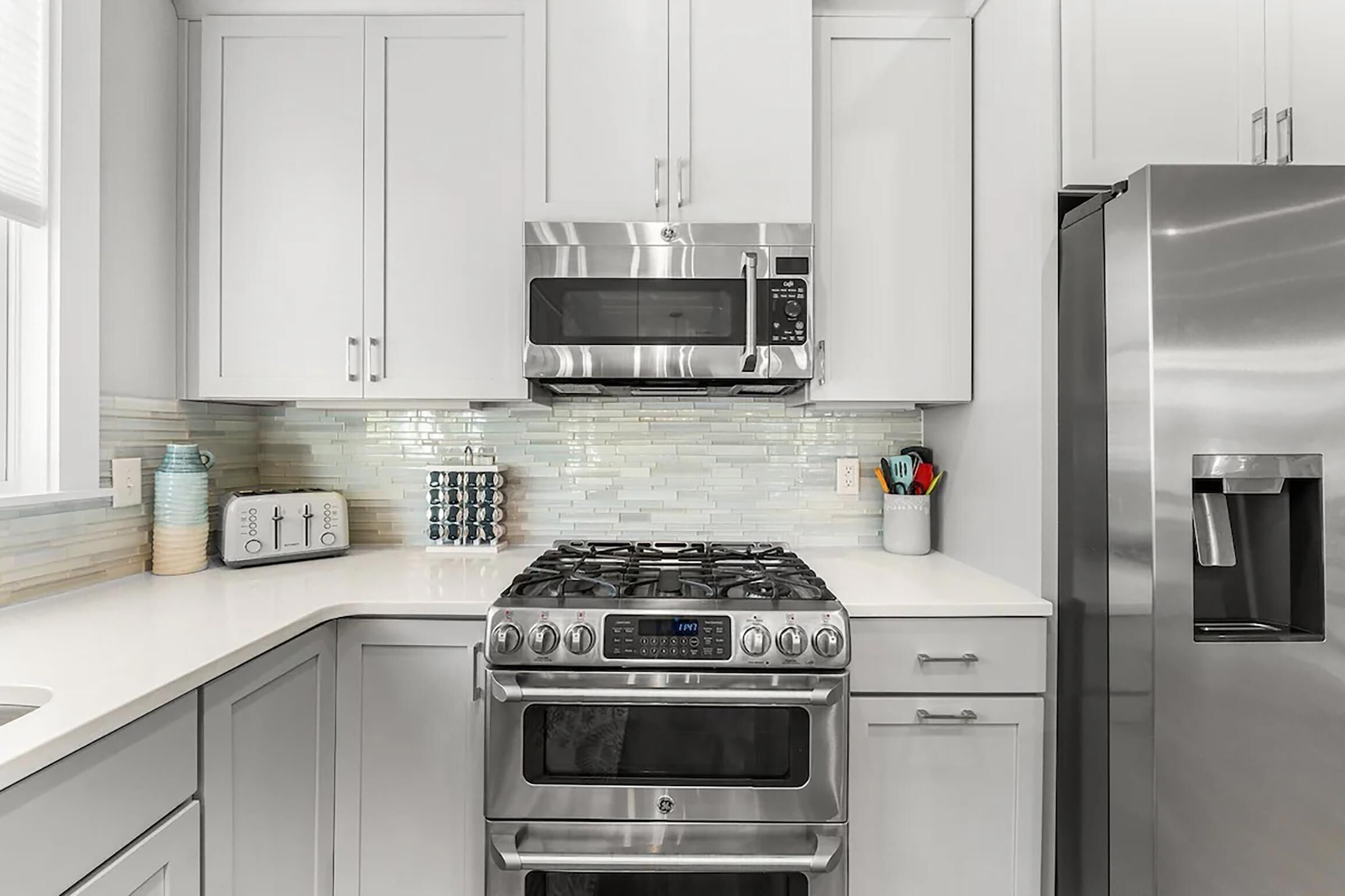 A modern kitchen with stainless steel appliances, including a microwave, oven, and refrigerator.