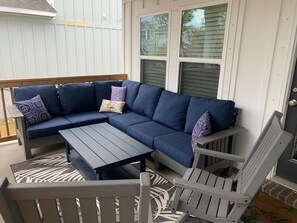 Relax in a serene outdoor seating area with a sofa, coffee table, and Adirondack chairs.