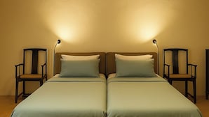 A double bed with two bedside tables, each with a lamp, in a room with wooden flooring. - Métairie du Hellès (Lanmeur)