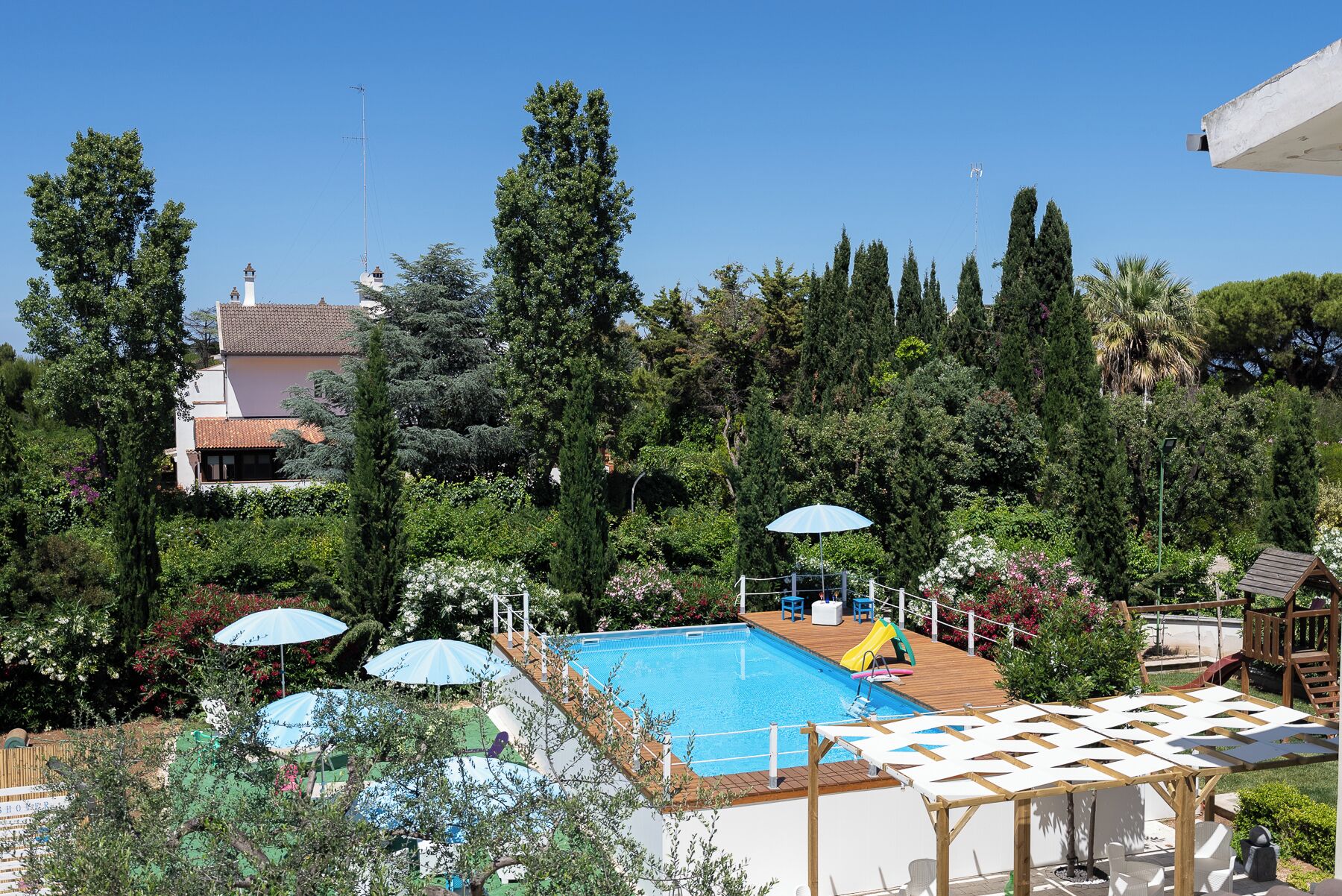 Una piscina al aire libre de temporada, sombrillas