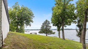 Une zone herbeuse avec des arbres et une étendue d'eau en arrière-plan.