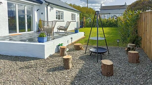 A house with a patio, outdoor seating, and a swing set. - Aberporth 2-bed Cottage , Sleeps 4 & Pet Friendly (Cardigan)