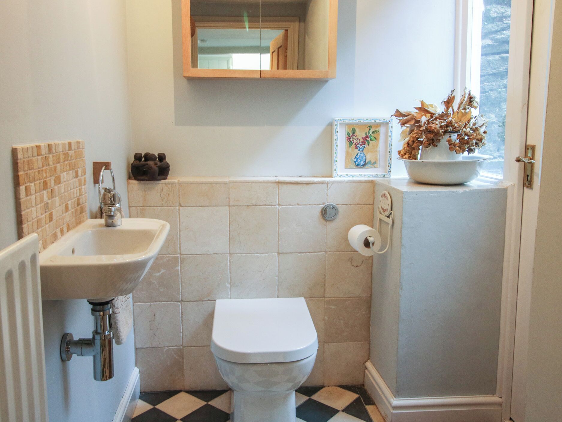 Une salle de bain avec un lavabo, des toilettes et une fenêtre donnant sur un beau paysage.