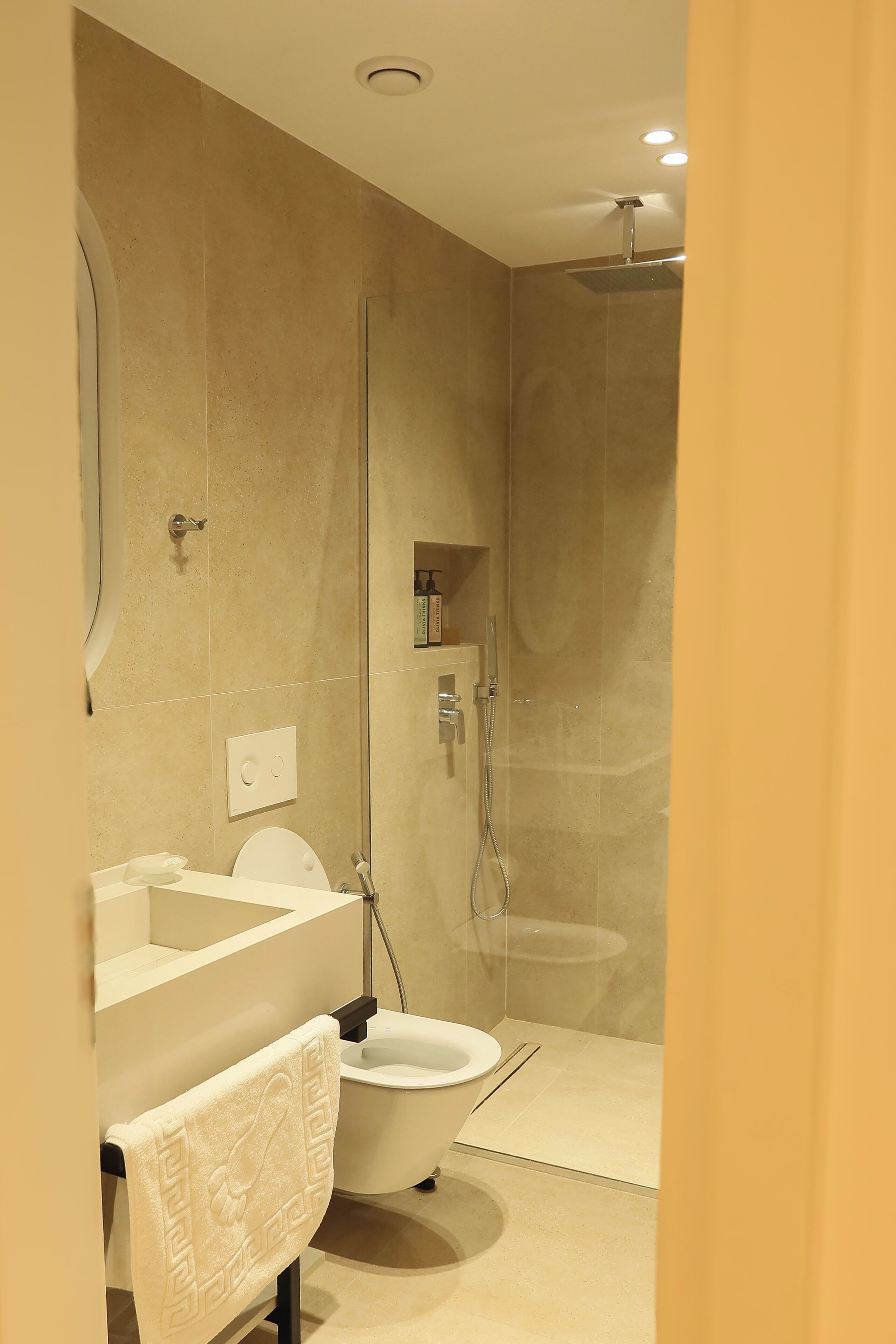 Un baño moderno con inodoro, lavamanos y ducha.