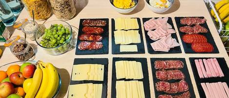 A table with various food items including cheese, meats, and fruits.