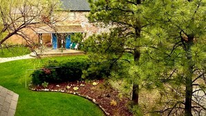 Zona residencial con una casa que tiene un porche cubierto y un césped bien cuidado.