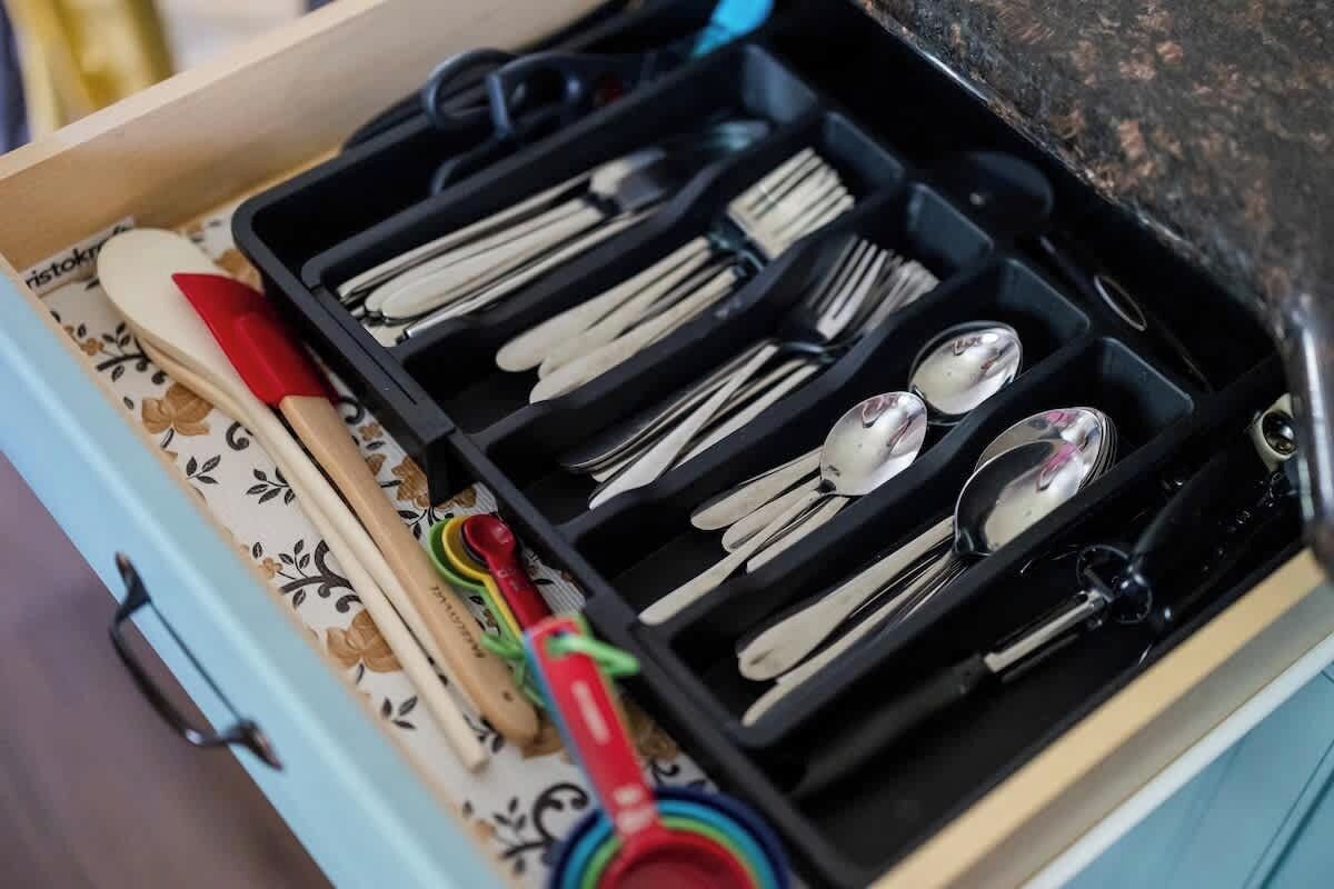 A drawer with utensils and measuring tools.