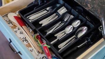 A drawer with utensils and measuring tools.