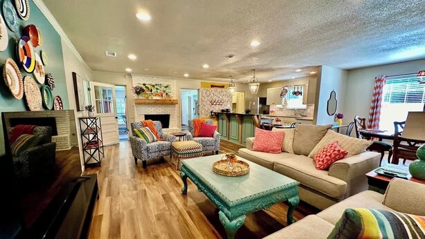 A spacious living room with a fireplace, a dining area, and a kitchen visible in the background. - Stylish home in Little Rock (Little Rock)
