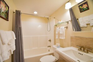 Ein Badezimmer mit Badewanne, Toilette, Waschbecken und Dusche.