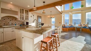 Una cocina amplia con una isla grande, vigas de madera y vistas al exterior.