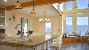 Una cocina amplia con una isla grande, vigas de madera y vistas a las montañas.