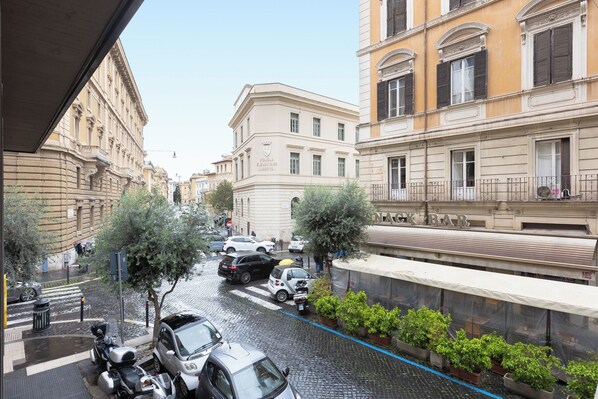 Une rue étroite, bordée de voitures garées et d’immeubles des deux côtés.
