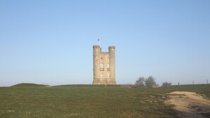 A tall, narrow stone tower with battlements, set in a grassy field. - Hand Built log Cabin at Avonvale Holiday Lodges (Evesham)