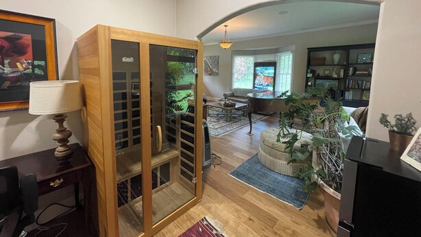 Ein Wohnzimmer mit einem Holzkabinett, einem Sofa, einem Couchtisch und einem Fernsehschrank.