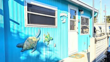 Un bâtiment bleu avec un porche, une fenêtre et une porte.