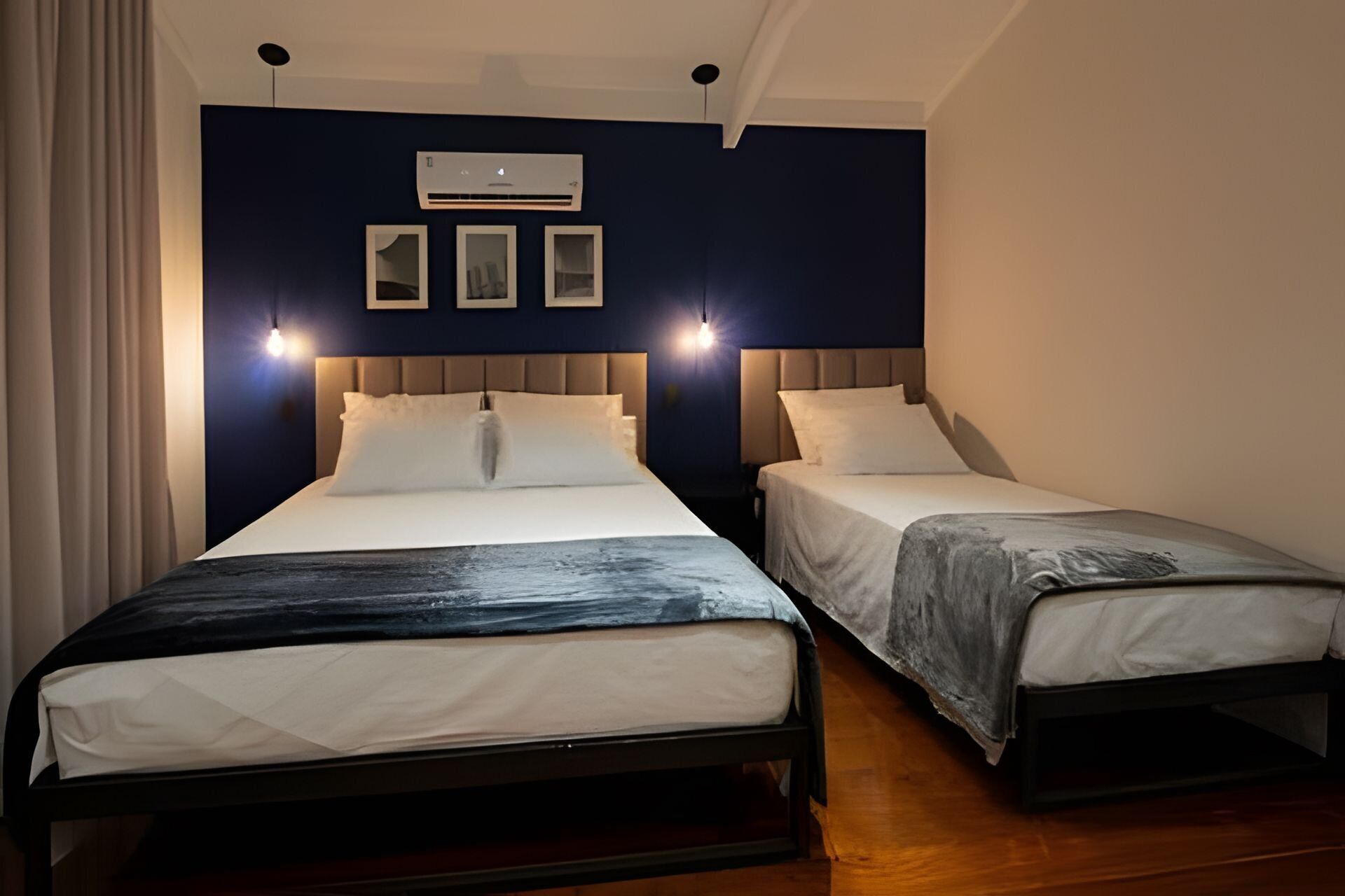 Una habitación de hotel con dos camas, ventilador de techo y aire acondicionado.