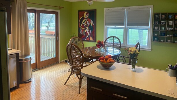 A dining area with a wooden table, chairs, and a bowl of fruit. There is a window with blinds, a ceiling fan, and a painting on the wall. - FIFA Coming to America! Minutes to MetLife Stadium & NYC ACTION! LET’S GO! (Emerson)