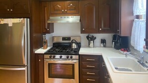 A kitchen with wooden cabinets, a stainless steel refrigerator, a stove, and a sink. - FIFA Coming to America! Minutes to MetLife Stadium & NYC ACTION! LET’S GO! (Emerson)