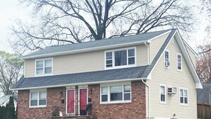 A two-story house with a brick facade, a front porch, and a garage. - FIFA Coming to America! Minutes to MetLife Stadium & NYC ACTION! LET’S GO! (Emerson)