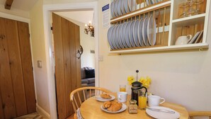 A dining area with a wooden table set for breakfast, including croissants and coffee.