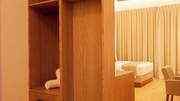 A bedroom with a wooden wardrobe, a bed, and a chair.