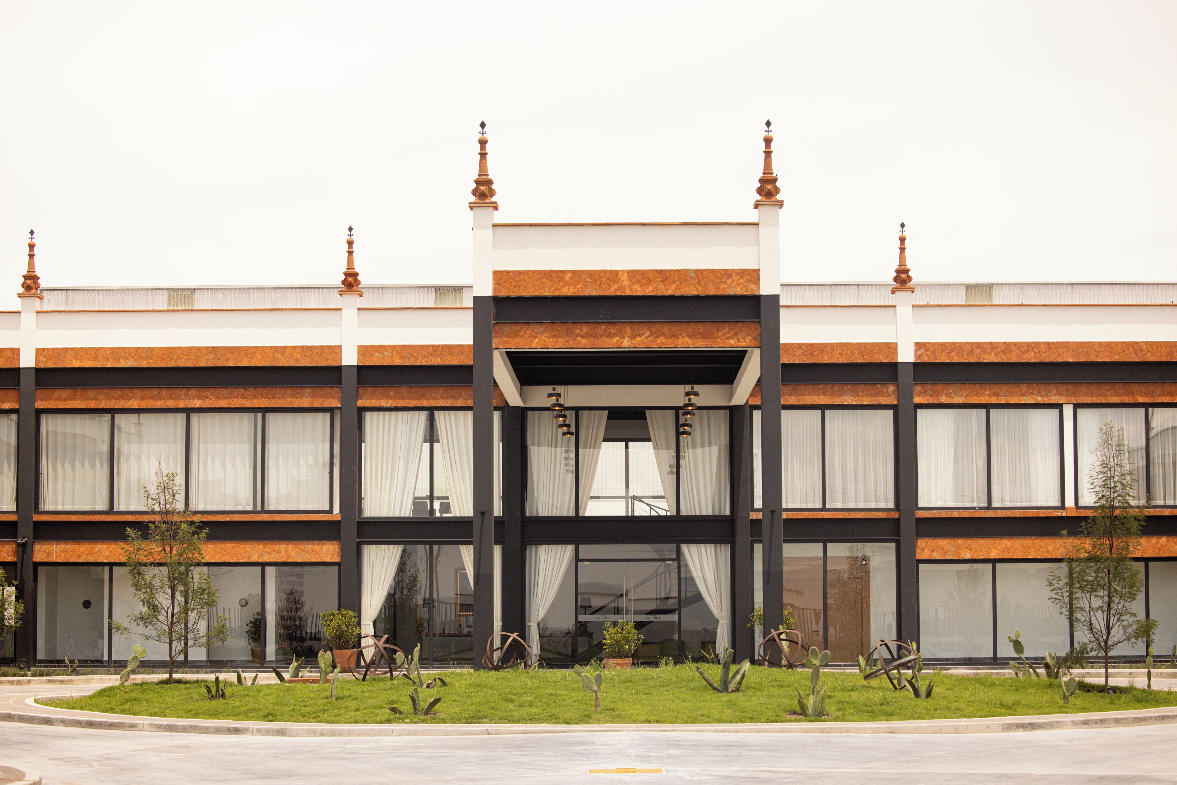 Un edificio moderno con fachada simétrica, amplias ventanas y una entrada central.