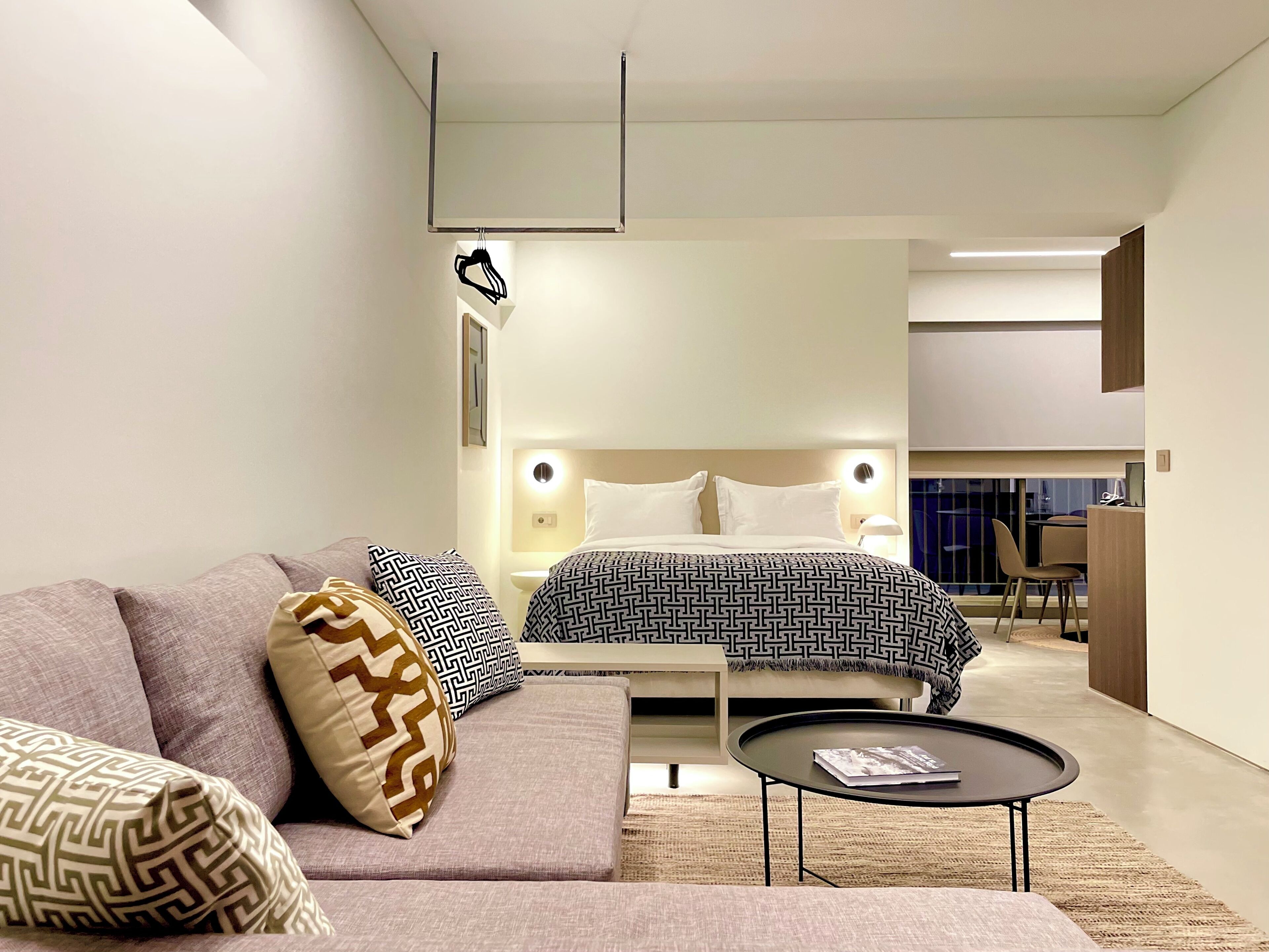 Ein modernes Hotelzimmer mit Bett, Sofa und einem kleinen runden Tisch.