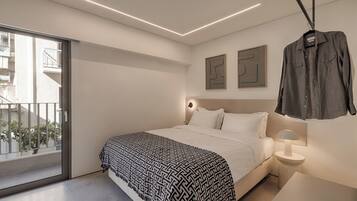 Quarto moderno com cama, mesa de cabeceira e uma camisa pendurada.