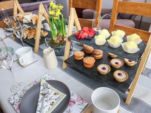 A dining table with various pastries, a pitcher, and a floral napkin.