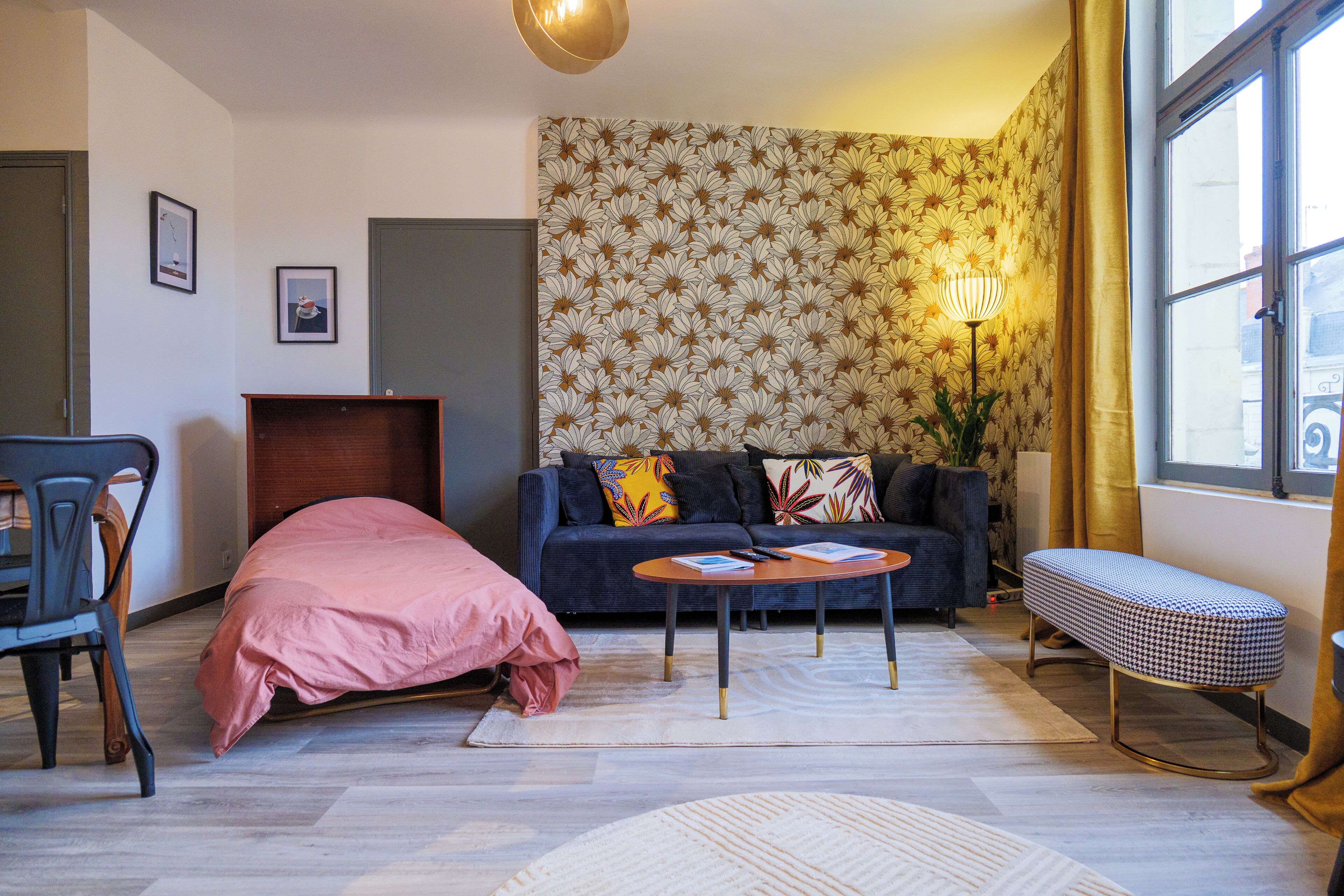 Una sala de estar moderna con un sofá, un banco, una mesa de centro y una cama.
