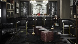 Un espace bar doté de sièges en cuir, d’un comptoir et d’un éclairage décoratif.