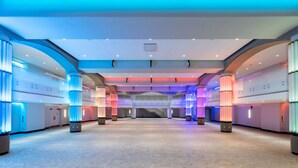 Un hall d’hôtel spacieux, doté d’un plafond haut, de plusieurs niveaux et d’un éclairage moderne.