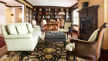 A cozy living room with a large bookshelf, a fireplace, and comfortable seating.