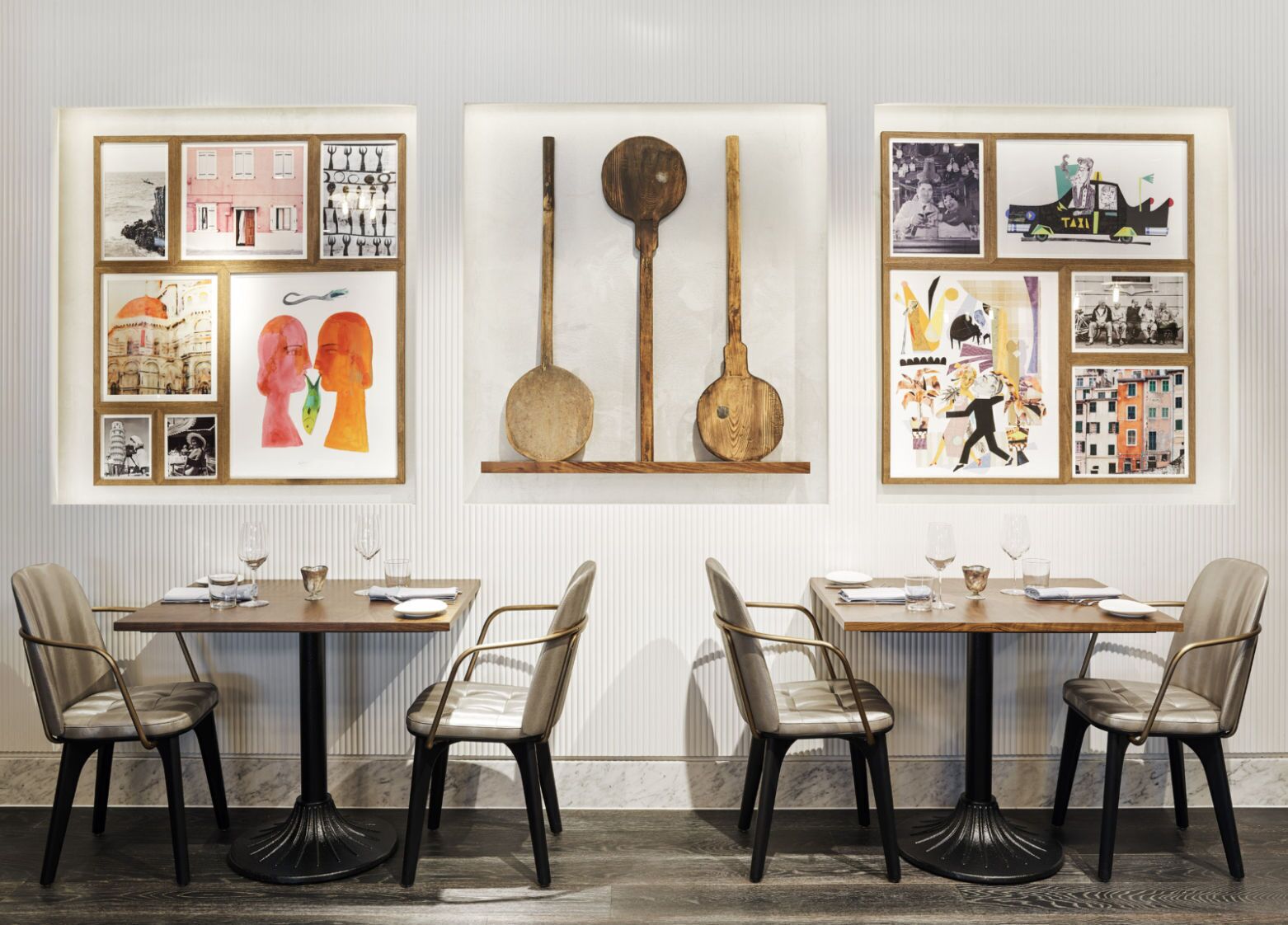 Un espace repas comprenant deux tables, chacune entourée de quatre chaises. Les murs sont décorés d’œuvres d’art encadrées, notamment des photographies et des peintures.