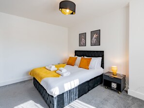 A modern bedroom with a large bed, a bedside table, and a lamp. - Hawkwell Retreat 5 Bedroom home | Hockley - Pass the Keys (Hawkwell)
