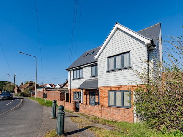 A residential street with houses, a clear sky, and a parked car. - Hawkwell Retreat 5 Bedroom home | Hockley - Pass the Keys (Hawkwell)