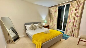Een moderne slaapkamer met een bed, een spiegel en een nachtkastje.
